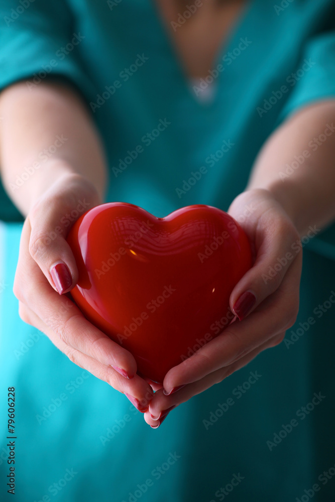 Female doctor with stethoscope holding heart over white Female doctor with stethoscope holding heart over white