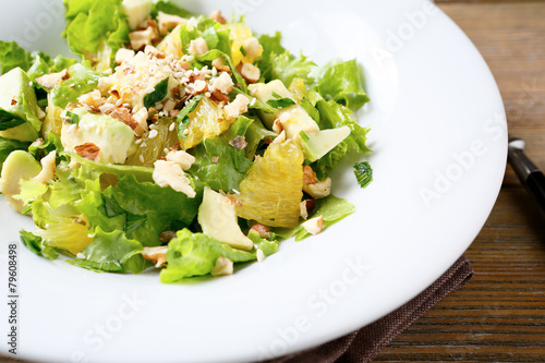 Fresh salad with avocado, lettuce, orange and crushed nuts