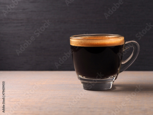 Cup of hot espresso coffee on wood board