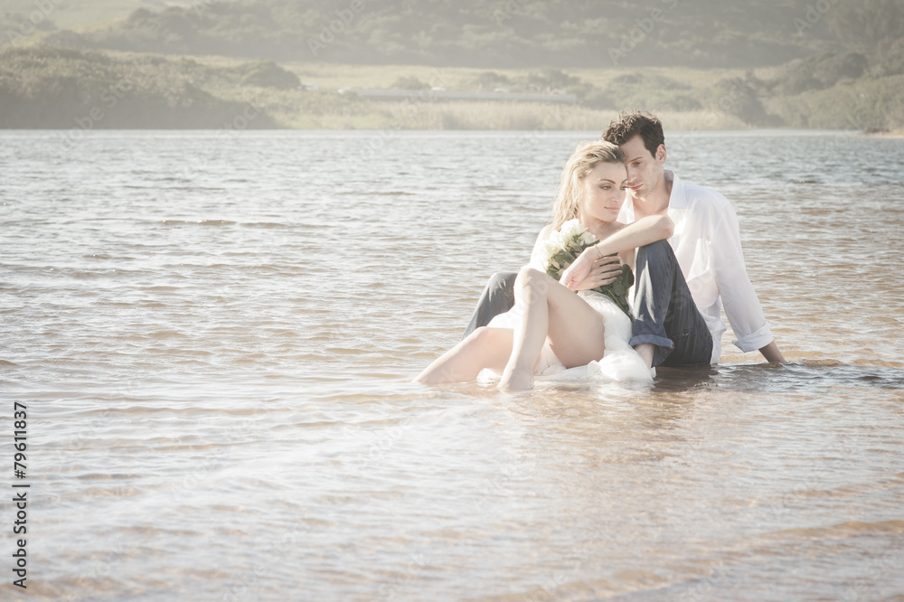 Young beautiful couple sitting in water flirting in love