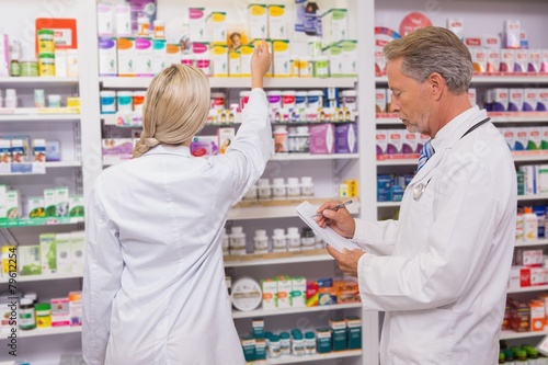 Pharmacist holding writing on clipboard