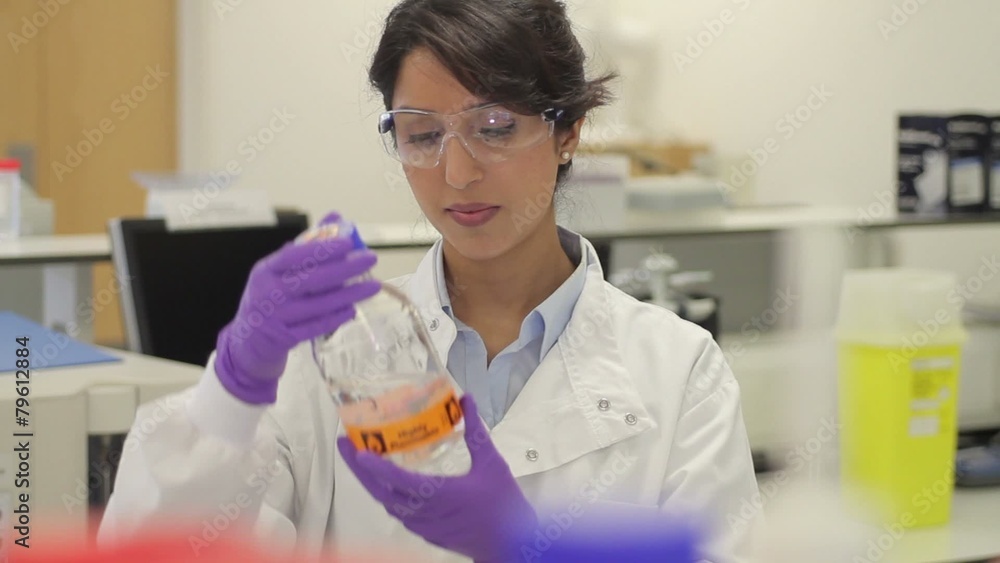 Scientist looking at liquid in laboratory Scientist looking at liquid in laboratory