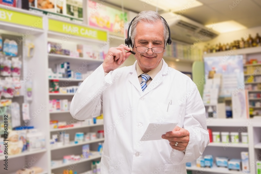 Senior pharmacist with headphone reading prescription