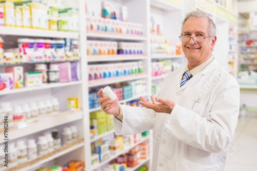 Smiling senior pharmacist showing medication