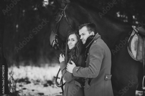 vintage black and white portrait of pretty couple with horse