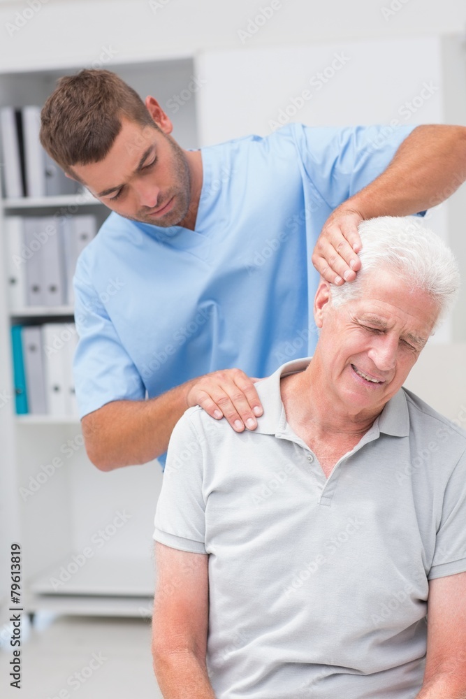 Obraz premium Therapist giving massage to senior male patient