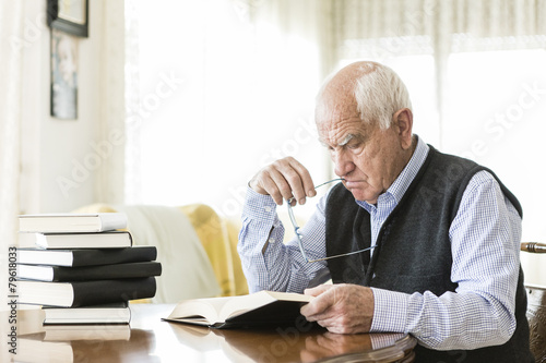 Senior man reading book relaxed at home