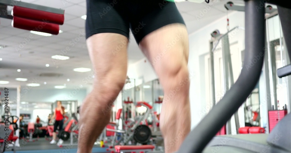 Strong male sports leg on a simulator orbitrek Strong male sports leg on a simulator orbitrek