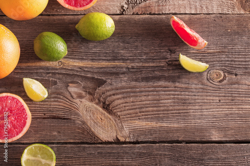 Set of sliced citrus fruits over wooden background