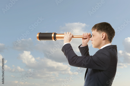 Businessman looks through a telescope