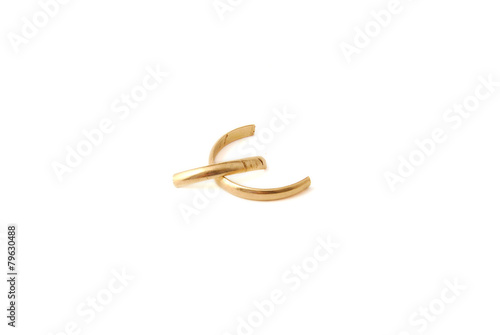 Broken wedding golden ring on white background. Divorce concept