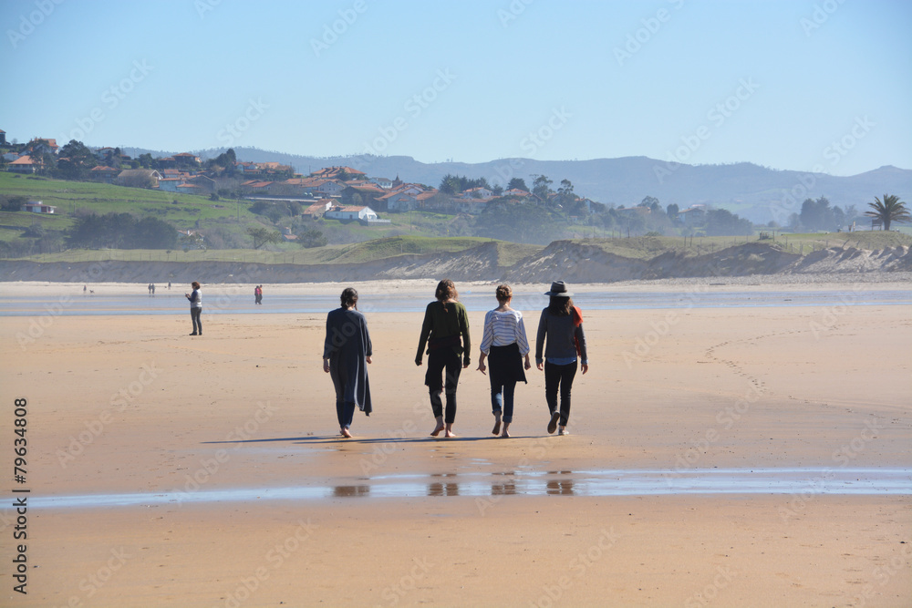 grupo de chicas paseando por la playa de oyambre