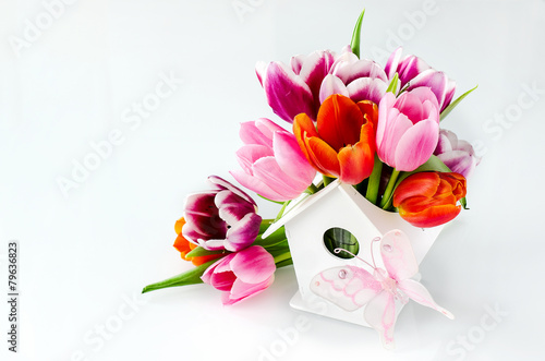 Bunch of tulips in birdshouse vase for mothers day photo