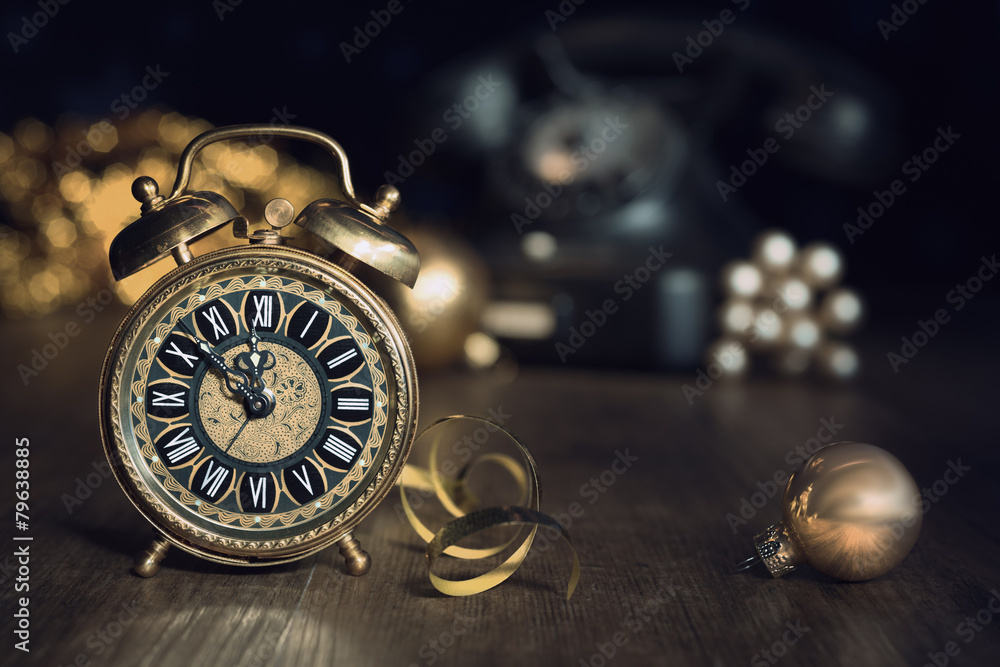 Composition with vintage alarm clock showing five to midnight