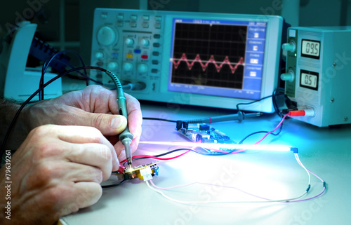 Tech tests electronic equipment in service centre photo