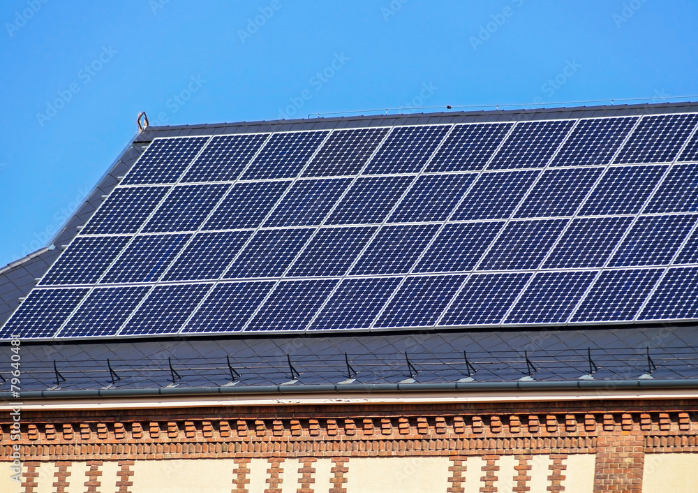 Naklejka premium Solar panels on the roof of an old building
