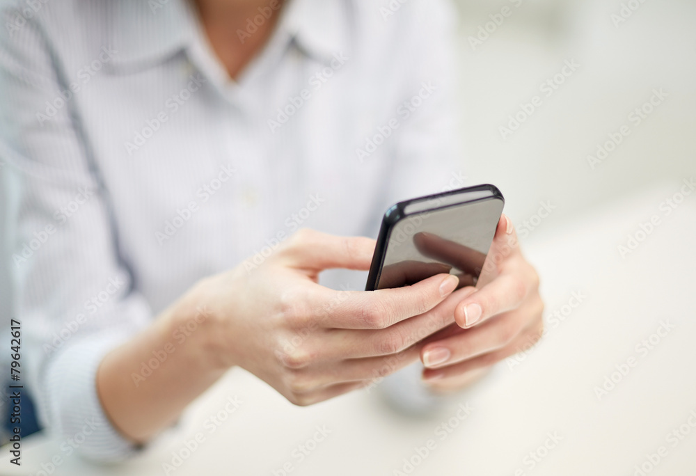 close up of woman texting on smartphone at office close up of woman texting on smartphone at office