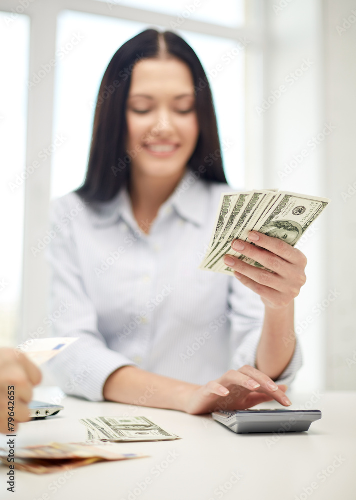 close up of woman counting money with calculator close up of woman counting money with calculator