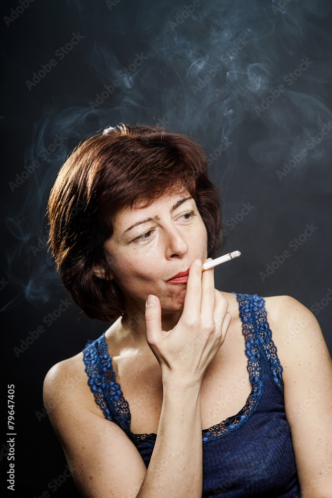 Obraz premium Young woman smoking cigarette, healthcare concept
