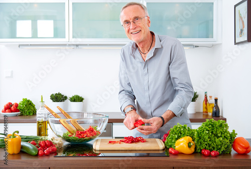 Mature man in the kitchen prepare salad X