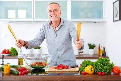 Mature man in the kitchen prepare salad IV