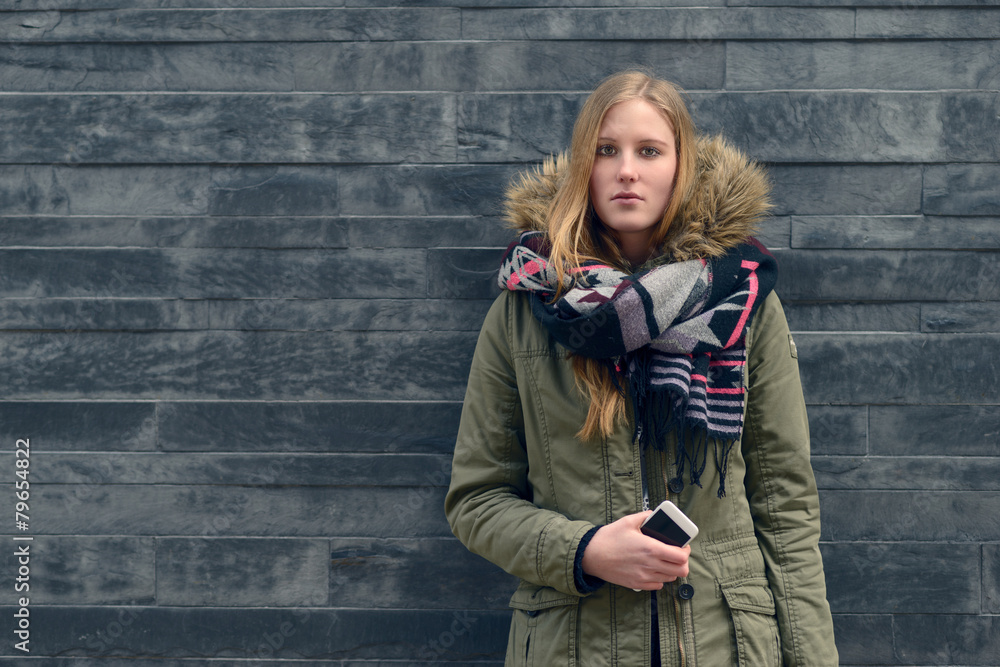 Frau in Winterbekleidung vor einer grauen Wand Frau in Winterbekleidung vor einer grauen Wand