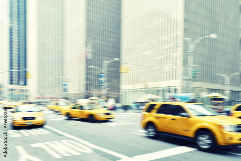 Blurred image of yellow taxis in the streets of New York City