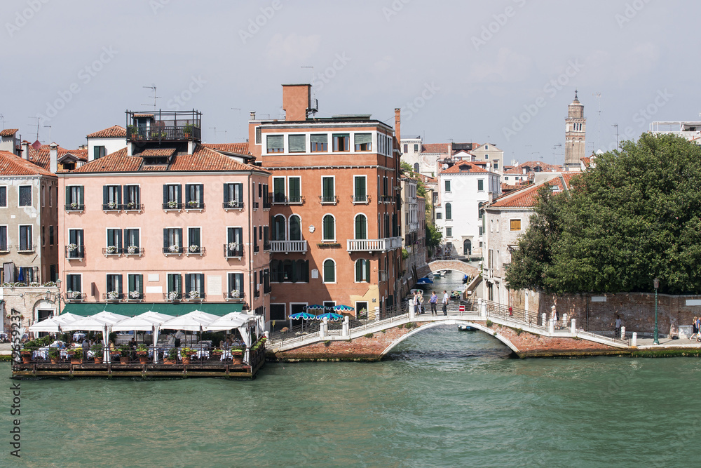 Quay, restaurant and bridge over channel in Venice