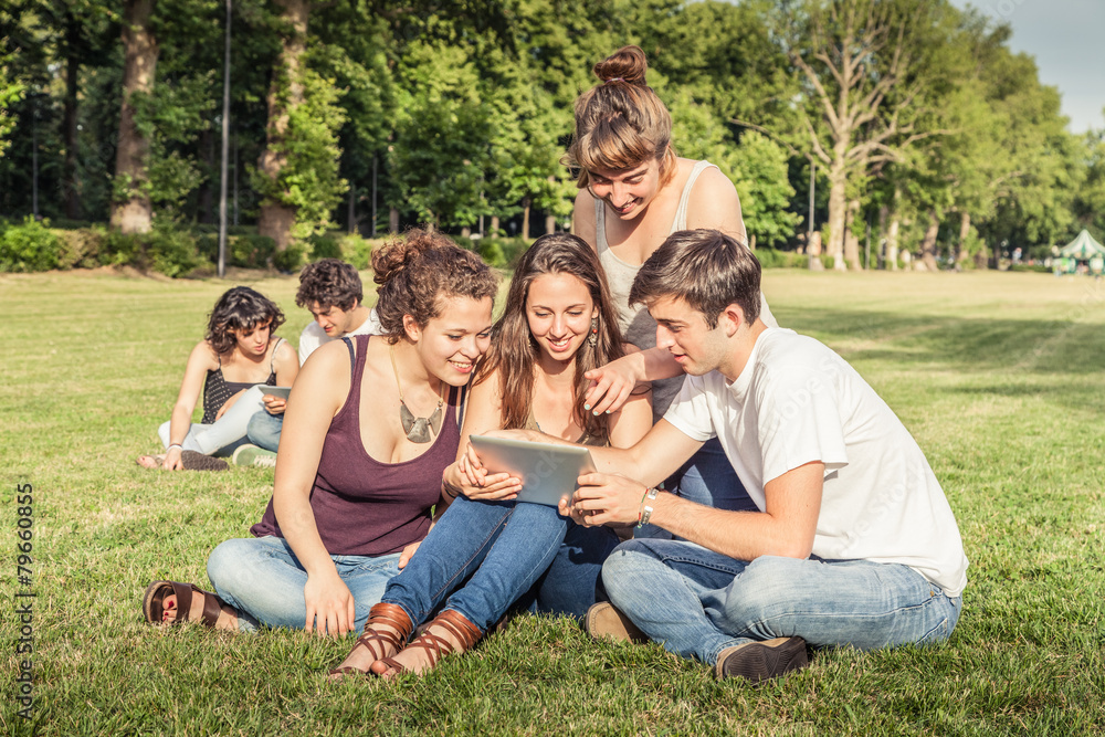 Friends using tablet in the park Friends using tablet in the park