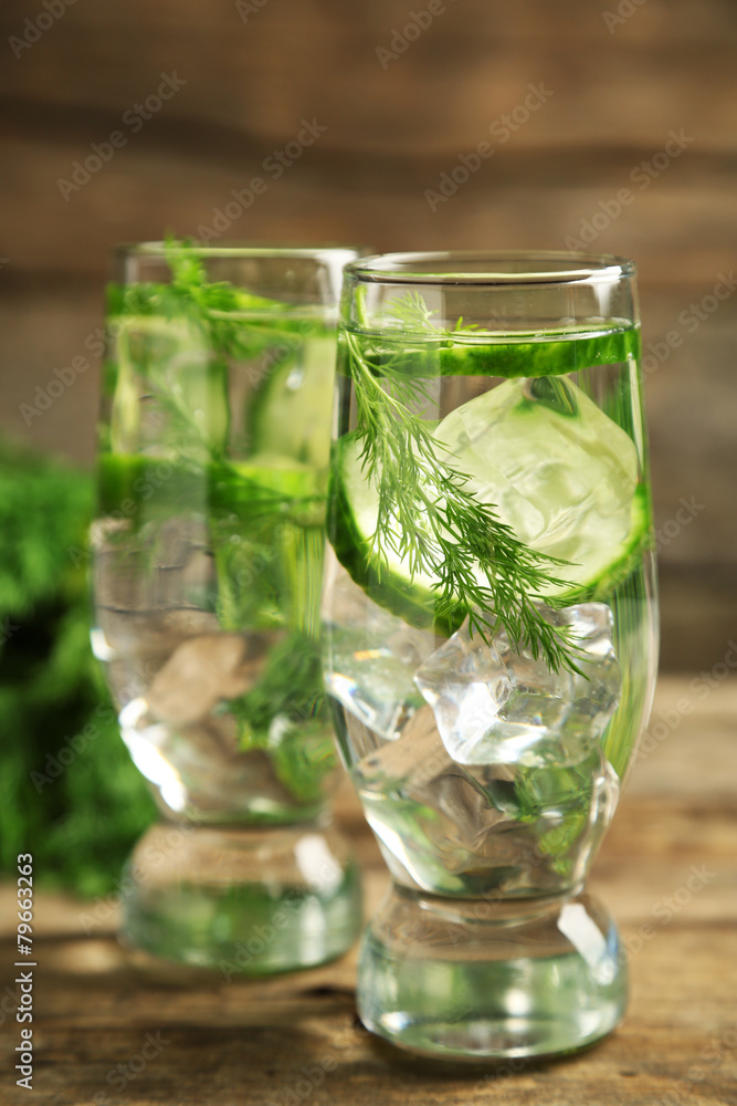 Glasses with fresh organic cucumber water on wooden table Glasses with fresh organic cucumber water on wooden table