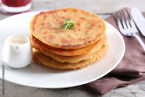 Stack of corn tortillas with stuffing and glass of juice
