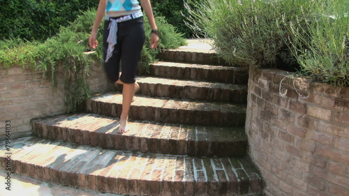 Barefoot woman in a garden going down a staircase among lavender