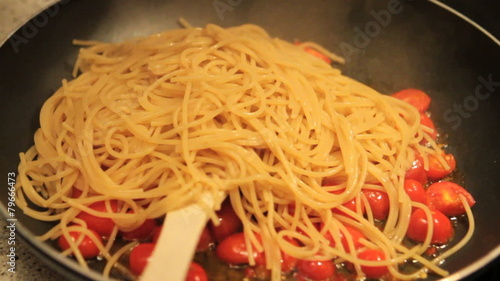 Cooking pasta (spaghetti) with fresh pachino tomatoes, close-up