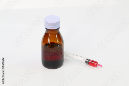 Bottle pouring Medicine Syrup in Spoon