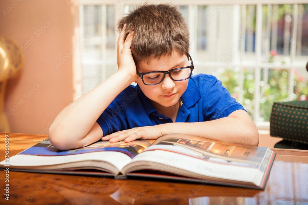 Little boy reading a big book