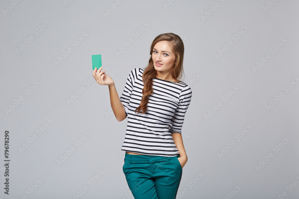 Happy smiling girl in casual clothing, showing blank credit card Happy smiling girl in casual clothing, showing blank credit card