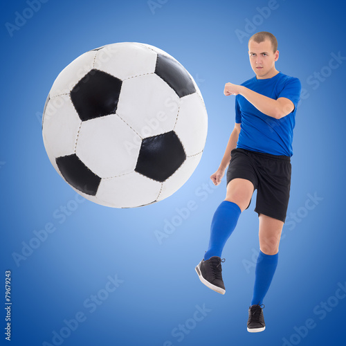 young soccer player kicking ball over blue