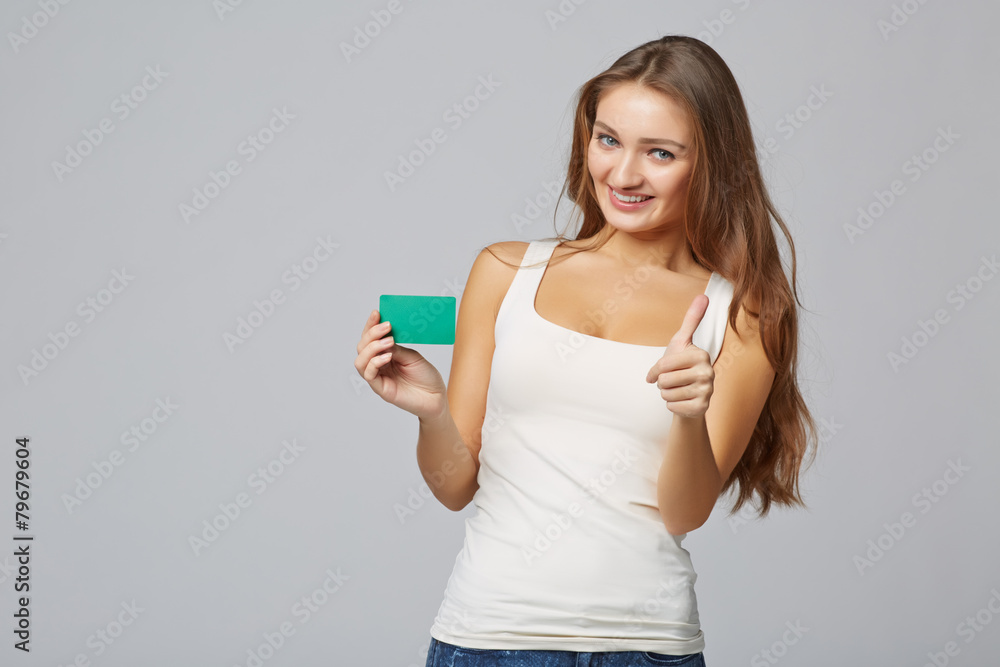 Happy smiling girl in casual clothing, showing blank credit card Happy smiling girl in casual clothing, showing blank credit card