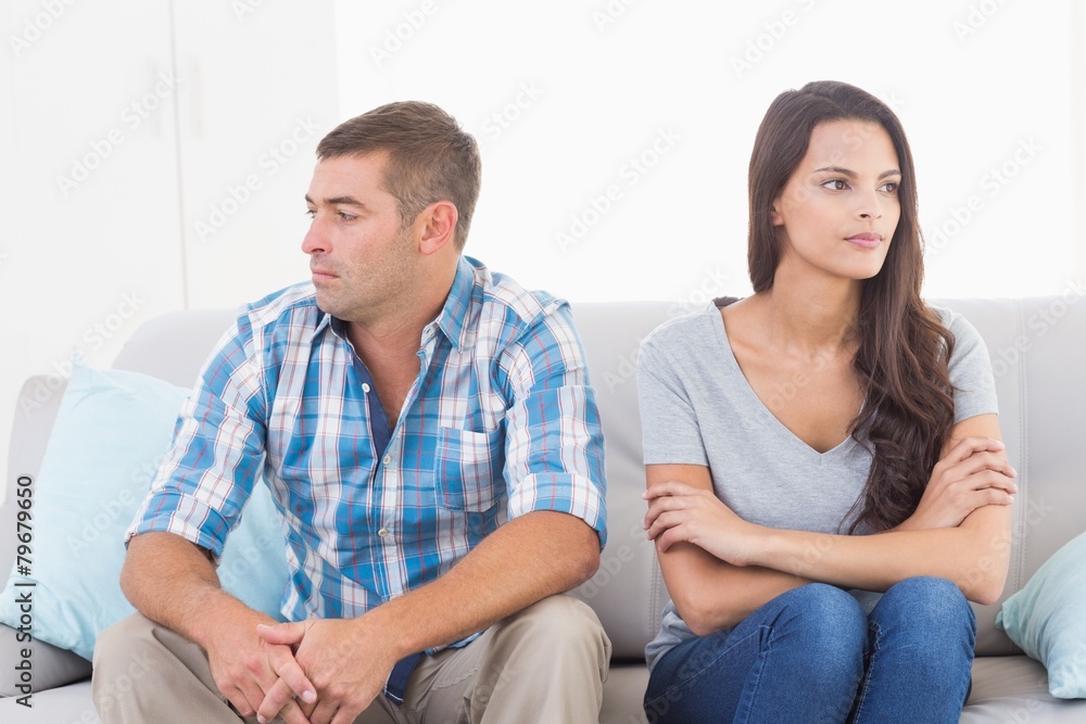 Couple looking away while sitting on sofa Couple looking away while sitting on sofa