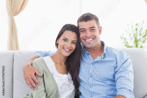 Happy loving couple sitting on sofa