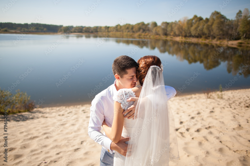 bride and groom, kissing on a beach bride and groom, kissing on a beach