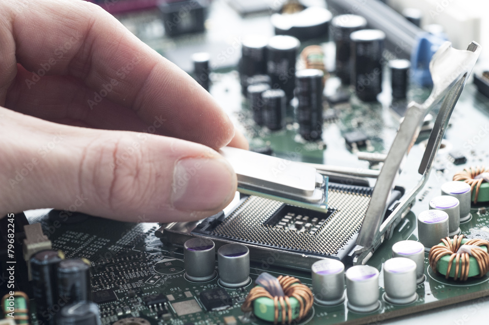 Technician inserting CPU in motherboard Technician inserting CPU in motherboard