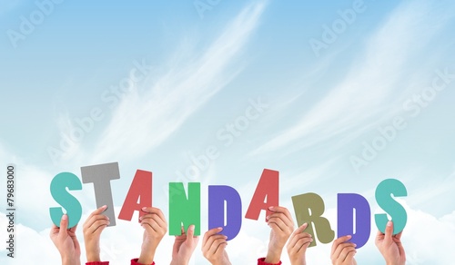 Composite image of hands holding up standards