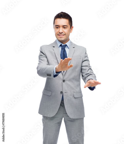 happy businessman in suit touching something