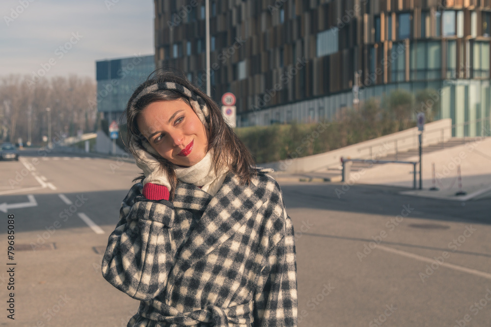 Fototapeta premium Beautiful young brunette posing in the city streets