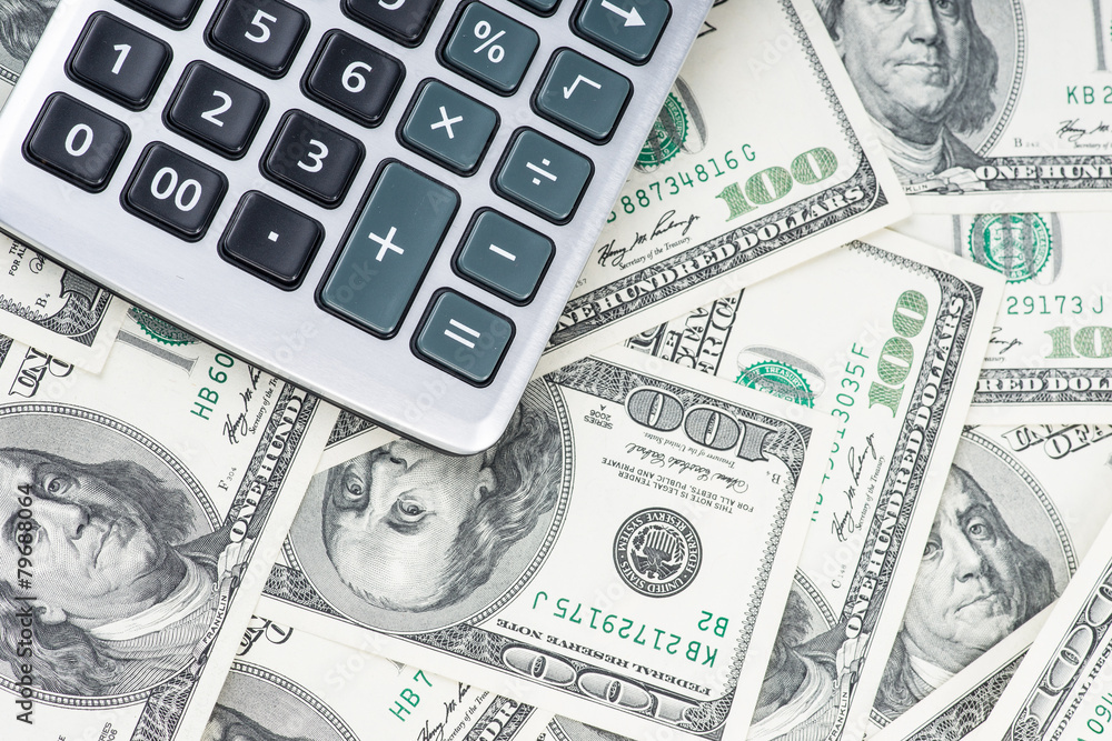 U. S. Dollars and calculator. Studio shot. U. S. Dollars and calculator. Studio shot.