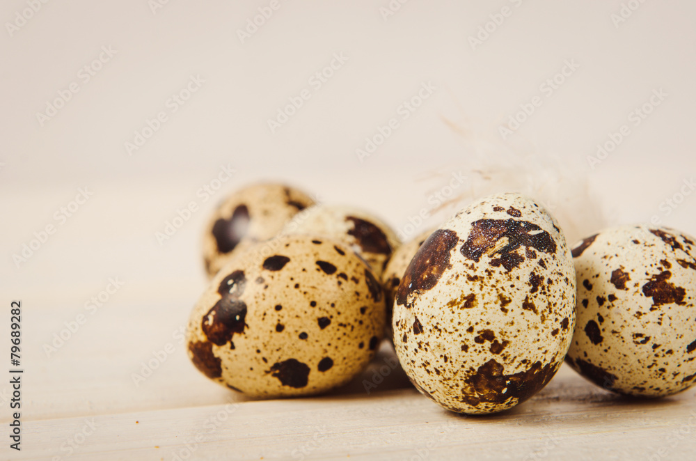 quail eggs stacked in a pile on white wooden table quail eggs stacked in a pile on white wooden table