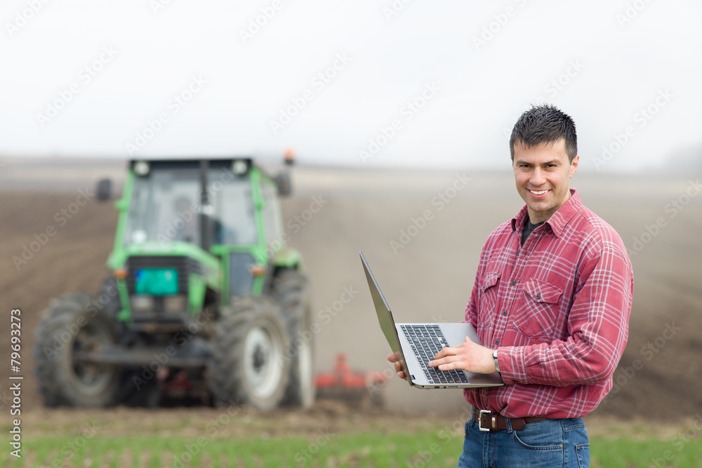 Obraz premium Farmer with laptop on field