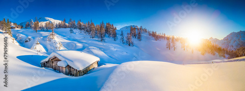 Winter landscape in the Alps at sunset with old mountain cottage