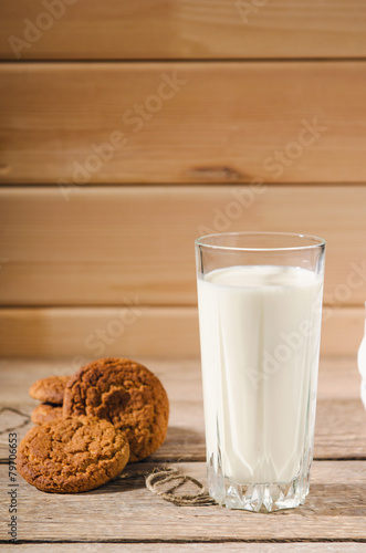 rustic oatmeal cookies on wooden table with a glass of milk